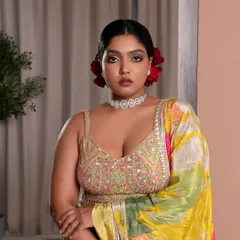 A full-length view of the "desi Frida Kahlo" inspired look. The makeup holds its own against the vibrant, multi-colored lehenga, creating a powerful and cohesive image for the brand's bridal collection launch.