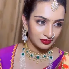 A side profile of Shravya's look, highlighting the elegant updo and the stunning diamond jhumkas. The makeup is sculpted to look perfect from every angle.