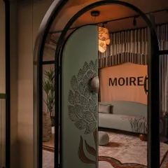 The entrance sets the tone for the entire experience. We designed this arched door to be a statement of intent, wrapping it in a custom-embellished fabric with a 3D floral motif. It’s a tactile invitation that signals this is no ordinary boutique.