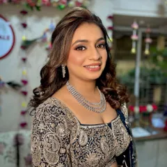 A happy, smiling portrait of the bride. The makeup is designed to look stunning both in person and under the bright lights of a Sangeet night.