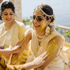 A bride enjoying her Haldi ceremony, surrounded by friends and family. We focus on creating a comfortable and happy environment so you can soak in every moment of these special rituals.