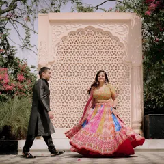 A vibrant and playful moment at The Picture Villa in Delhi. The bride's colorful lehenga stands out beautifully against the intricate architecture, creating a stunning pre-wedding photo.