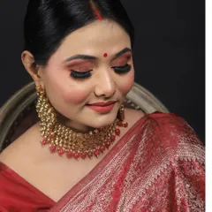 A close-up shot with eyes closed to showcase the beautiful red and gold eyeshadow blend. This soft glam look is perfect for weddings, receptions, and festive occasions.