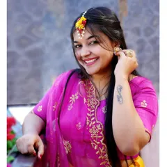 A joyful portrait of a bride-to-be at her Haldi ceremony. The bright pink and yellow outfit perfectly complements the festive mood.