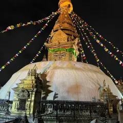 The magnificent Bouddhanath Stupa illuminated at night, with prayer flags carrying intentions to the heavens. Its grand mandala structure is a powerful tool for meditation and inner alignment.