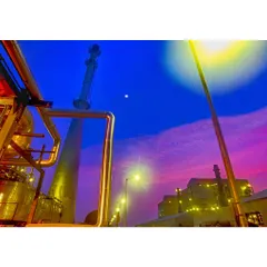 This industrial landscape at twilight uses vibrant, contrasting colors to create a surreal and powerful image of a power plant against the evening sky.