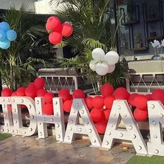 Large, light-up letters spelling out the birthday boy's name, placed outdoors to welcome guests to the party venue.