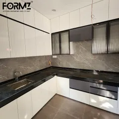 Another angle of the white U-shaped kitchen, focusing on the sink area and surrounding cabinetry. The combination of solid and fluted glass doors adds visual texture to the space.