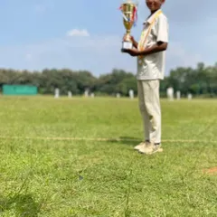 A low-angle shot capturing a young player holding his trophy, symbolizing the heights he can reach with dedication.