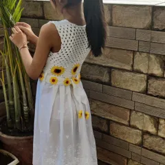 My daughter, my biggest inspiration, wearing her custom sunflower frock. Seeing her twirl in something I made just for her is the purest joy. This piece combines a light, airy dress with a hand-crocheted sunflower bodice and belt, perfect for special occasions or just feeling like a princess.