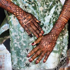 A special bridal design featuring the groom's initial 'N' on one hand and the bride's initial 'K' on the other, along with the phrase 'Nawaz ki Dulhan' (Nawaz's Bride).