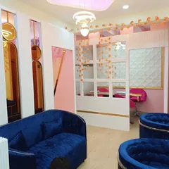 A view of the waiting lounge and nail stations at our newly opened Koramangala branch. The design uses a bold color palette with blue velvet and pink accents to create a memorable look.