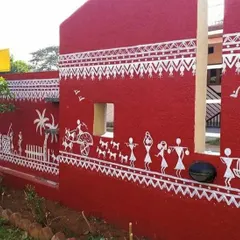 This angle highlights the narrative flow of the Warli art along the length of the compound wall. The white stick figures and motifs stand out beautifully against the earthy red, creating a timeless and culturally rich look.