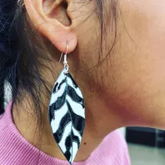A student wearing the beautiful leaf-patterned enamel earrings she created from scratch in our two-day workshop.