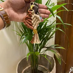 This two-tone heart charm keychain in brown and beige is a popular choice. The gold-wrapped tassel and sturdy clasp make it a lovely car or bag accessory.