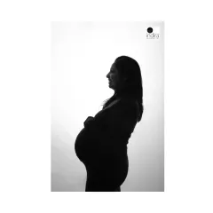 A smiling profile silhouette of the mother-to-be, capturing her joy and the beautiful curve of her pregnancy.