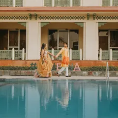 A serene moment during the Haldi festivities, as the couple takes a stroll by the pool. The reflection in the water adds a beautiful, artistic touch to the photograph.
