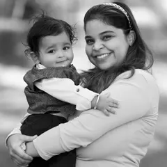 A slightly different angle of a mother and her baby, capturing a warm smile and the secure feeling of a mother's embrace.