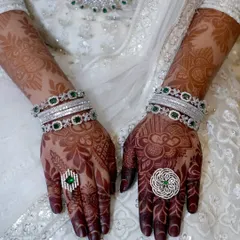 The beautiful initial stain of an engagement henna, perfectly complementing the client's stunning jewelry and white dress.