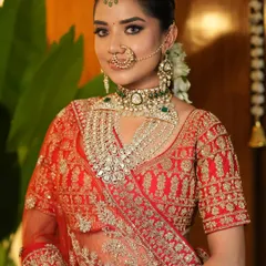 This bride's look is all about traditional grandeur. Her neat bridal bun is adorned with fresh gajra, perfectly complementing her red lehenga and heavy polki jewellery for the Pheras.