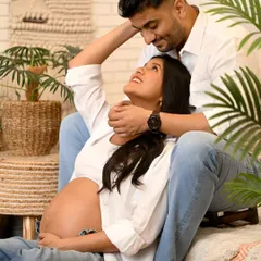 A tender moment between an expecting couple, sharing a look of love in a beautifully styled indoor setting. This maternity photo is full of warmth and anticipation.