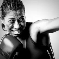 The power of an athlete. This black and white portrait of boxer Lovlina Borgohain captures the grit and determination in a single, intense moment of action. The focus is purely on her expression and the physicality of her sport.
