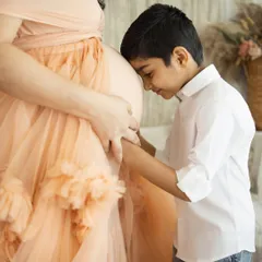 The sweetest moments are often the unscripted ones. Capturing the tender connection between a big brother and his soon-to-arrive sibling is what makes family photography so special.