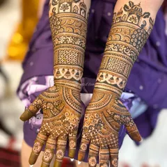 A stunning example of symmetrical bridal art, with palace-style domes at the top. The design is filled with intricate checks, floral bands, and hanging bells for a truly royal feel.
