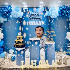 This is a glimpse into our 'Twinkle Twinkle Little Star' theme, where we create a dreamy celestial world. The setup features a custom backdrop, themed pedestals for the cake, and a multi-layered balloon arch in shades of blue, silver, and white to bring the night sky indoors.