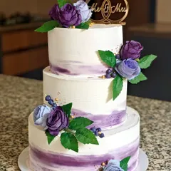 A classic three-tier wedding cake in a beautiful lavender watercolor effect, finished with delicate sugar flowers. I used whipped cream for a light, delicious taste, proving that large, structured cakes can be both stunning and free of heavy fondant.