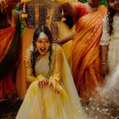 Capturing the pure, unscripted joy of a Haldi ceremony. The background shows our dense floral wall that adds to the celebratory feel of the event.