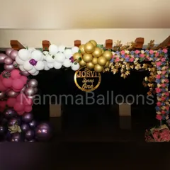The entrance to this first birthday party sets a festive tone with a beautiful balloon and floral arch. A custom sign with the child's name welcomes guests to the celebration.