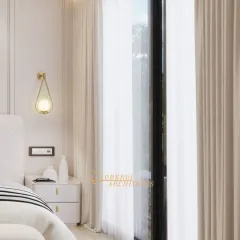 Natural light streams in through the large window, illuminating the soft, warm textures of the room. This corner showcases the delicate pendant light and minimalist nightstand.