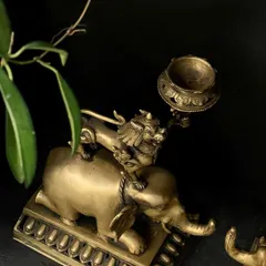A close-up of the Tibetan-style brass candle stand, showing the lion perched atop the elephant. This beautifully crafted vintage piece adds a unique Asian charm to any space.