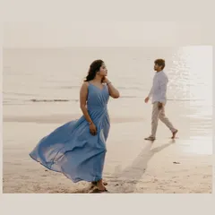 A candid shot of the couple on the beach, creating a sense of story and quiet contemplation by the ocean.