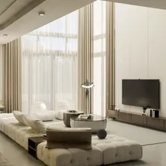 This sun-drenched, double-height living room is the definition of modern luxury. We used a long, modular sofa to anchor the vast space and kept the palette in soft, muted tones to create a serene and expansive atmosphere, letting the architecture and natural light take center stage.