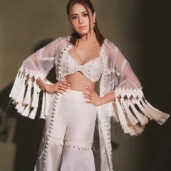 A powerful pose in this stunning white indo-western set. The fringed sleeves and intricate detailing on the pants make it a unique choice for a cocktail party.
