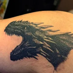 A color photograph of the finished Balerion tattoo, showing how the black ink settles into the skin. This piece required careful layering to achieve the dark, imposing look of the dragon.