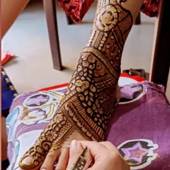Here I am applying a detailed peacock design to a bride's foot. The pattern is designed to beautifully complement the shape of the foot and ankle.