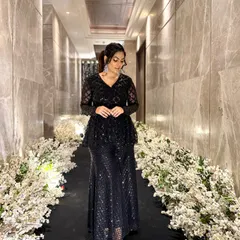 Walking through a beautifully decorated floral hallway, this black sequined outfit catches the light perfectly. The peplum silhouette is incredibly flattering and adds a modern touch.