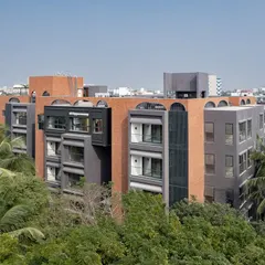 Aerial views of the ARCUS apartments in Chennai, showing how the building's form navigates the dense tree cover, creating a private oasis in the bustling T Nagar neighborhood.