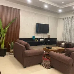 A minimalist living room design with a floating black TV console and a textured wood-paneled accent wall, creating a modern and uncluttered space.