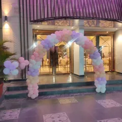 A closer view of the pastel balloon entrance arch. The mix of pink, purple, peach, and white balloons creates an inviting and festive entryway for guests arriving at the party venue.