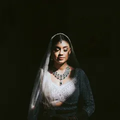 A study in light and shadow. This artistic bridal portrait uses a single sliver of light to illuminate the bride's face and jewelry, creating a dramatic and soulful image.