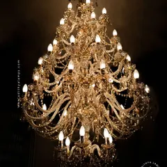 A detailed look at our magnificent multi-tiered crystal chandelier. Each arm is draped with shimmering crystal beads that reflect and refract light, creating an unparalleled sparkle. This fixture is a testament to classic European design and meticulous craftsmanship.