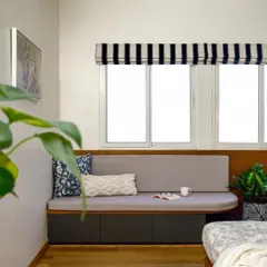 After: The same guest room transformed with a cozy, custom-built window seat, creating a perfect spot to relax and enjoy the natural light. This simple addition completely changes the feel of the room.