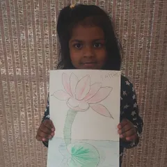 A young artist proudly holds her delicate drawing of a lotus flower.