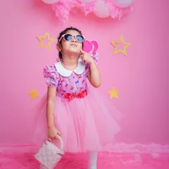 This little doll is serving looks. With sunglasses and a purse, our Barbie-themed shoot lets your child express their inner fashionista.