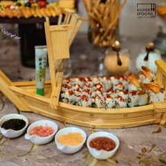 A close-up of the exquisite sushi boat, filled with handcrafted rolls and topped with tobiko. This display is a highlight of my global cuisine offerings for special events.