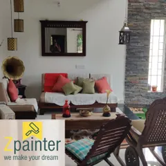A cozy living room with off-white walls that create a bright and airy feel. The neutral color provides a perfect backdrop for the rustic wooden furniture and stone accent wall.